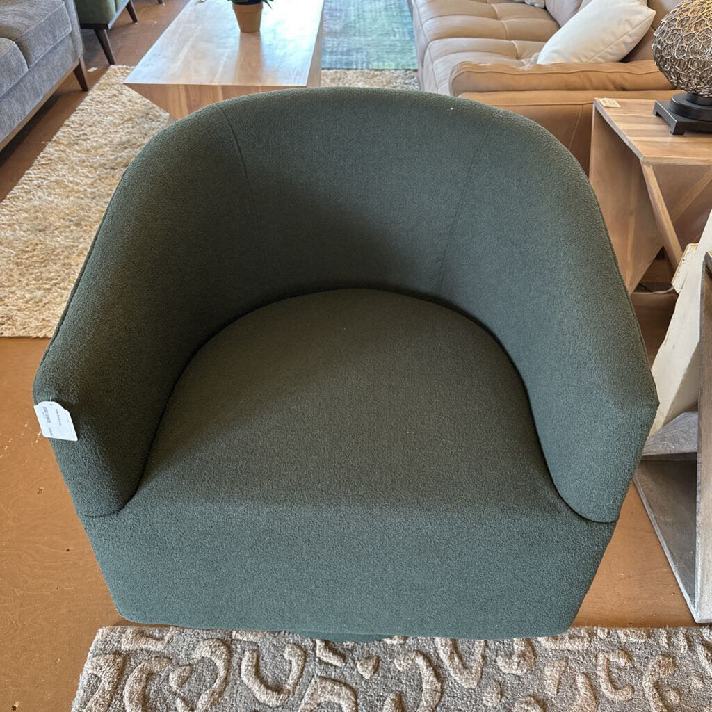 Green armchair in a living room setting with furniture and decor.