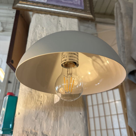 Light fixture with a visible bulb inside a gray and gold shade.