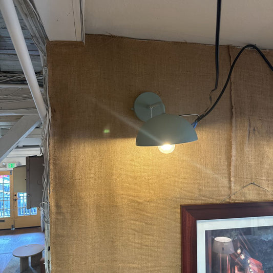 Wall-mounted light fixture on a textured wall with a blurred background