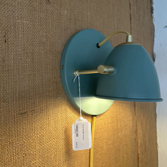 Blue wall lamp with a tag on a textured wall