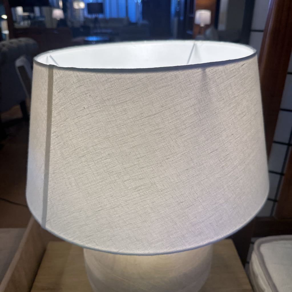 Textured lampshade on a lamp in an indoor setting