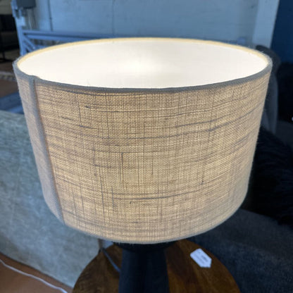 Textured lampshade on a lamp in an indoor setting