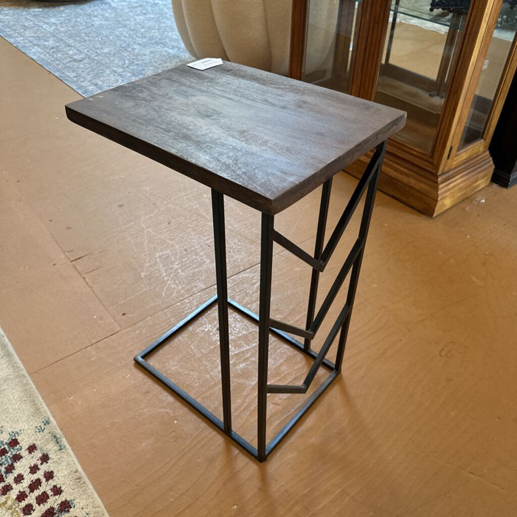 Small square table with a metal frame on a wooden floor