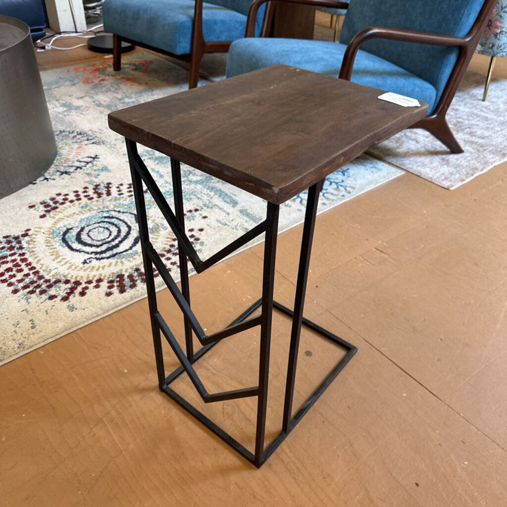 Wooden bar stool with metal frame on a cardboard surface