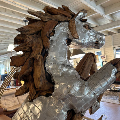 Large metallic horse sculpture in a showroom setting with furniture and decor.