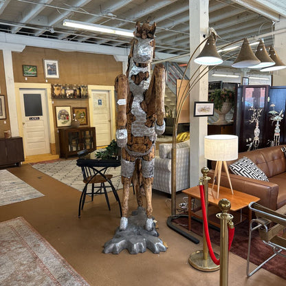Large metallic horse sculpture in a showroom setting with furniture and decor.