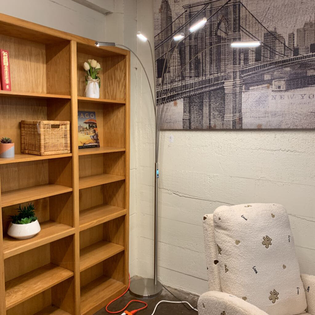 Wooden bookshelf with decorative items in a room with a cityscape wall art.
