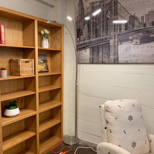 Wooden bookshelf with decorative items in a room with a cityscape wall art.