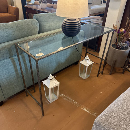 Glass console table with metal frame in a living room setting