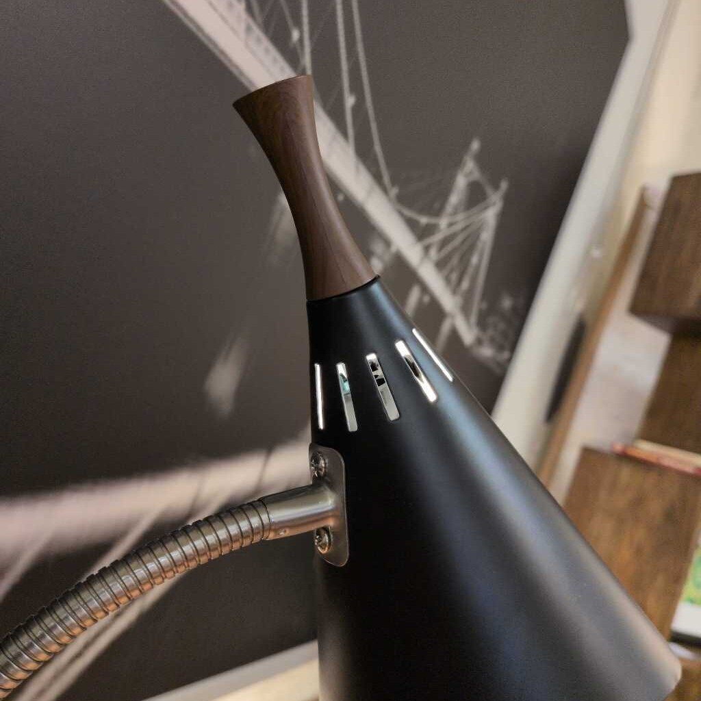 Black hair dryer with brown nozzle against a neutral background