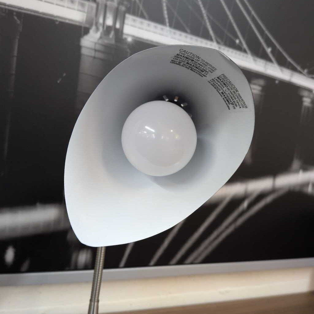 White lampshade with a bulb inside, blurred background of a bridge