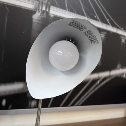 White lampshade with a bulb inside, blurred background of a bridge
