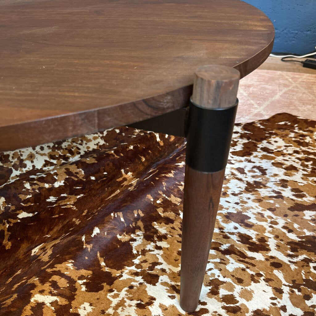 Wooden table leg with metal cap on a patterned surface