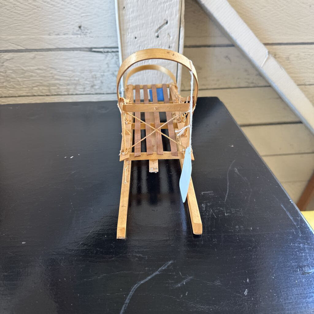 Small wooden chair on a black surface with a neutral background