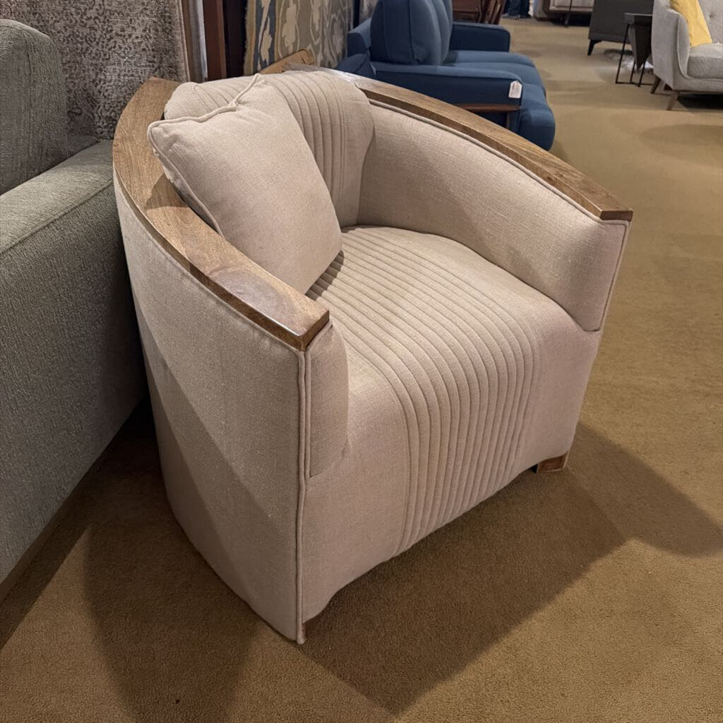 Beige armchair with wooden armrests in a showroom setting