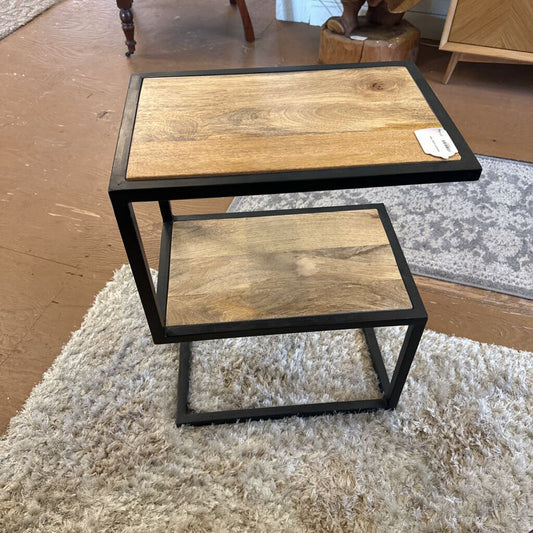 Two wooden tables with metal frames on a carpeted floor.