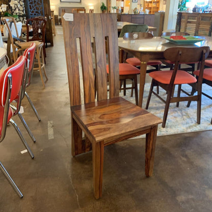 Wooden chair with red cushioned seat in a furniture store setting