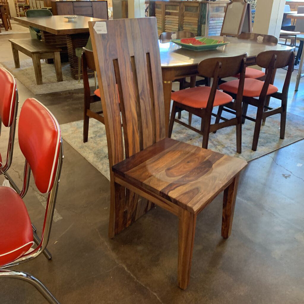 Wooden chair with red cushioned seat in a showroom setting