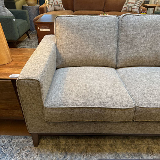 Gray sectional sofa in a room with furniture and decor.