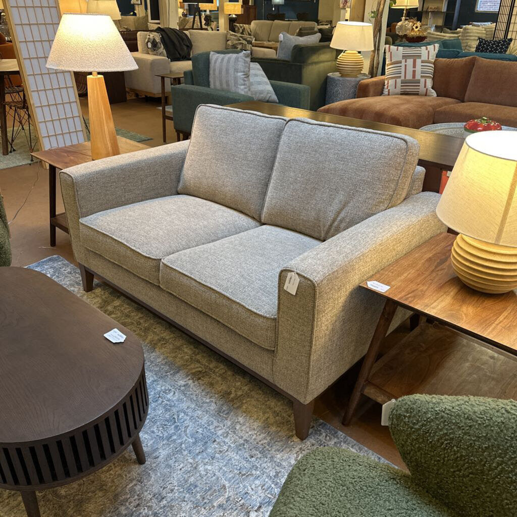 Gray sofa in a furniture store with other couches and lamps around