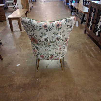 Floral-patterned chair in a store setting with other furniture items.