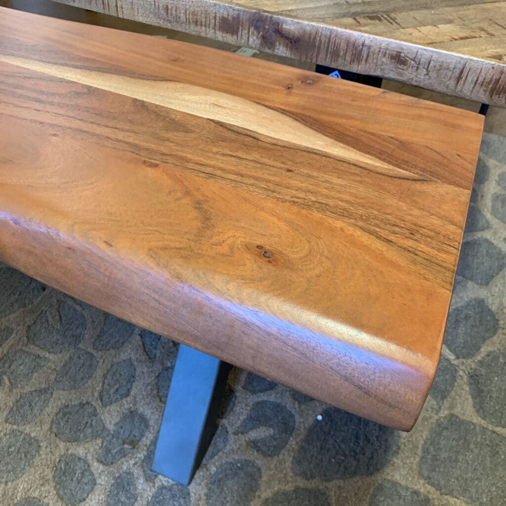 Wooden bench with a natural finish on a stone floor