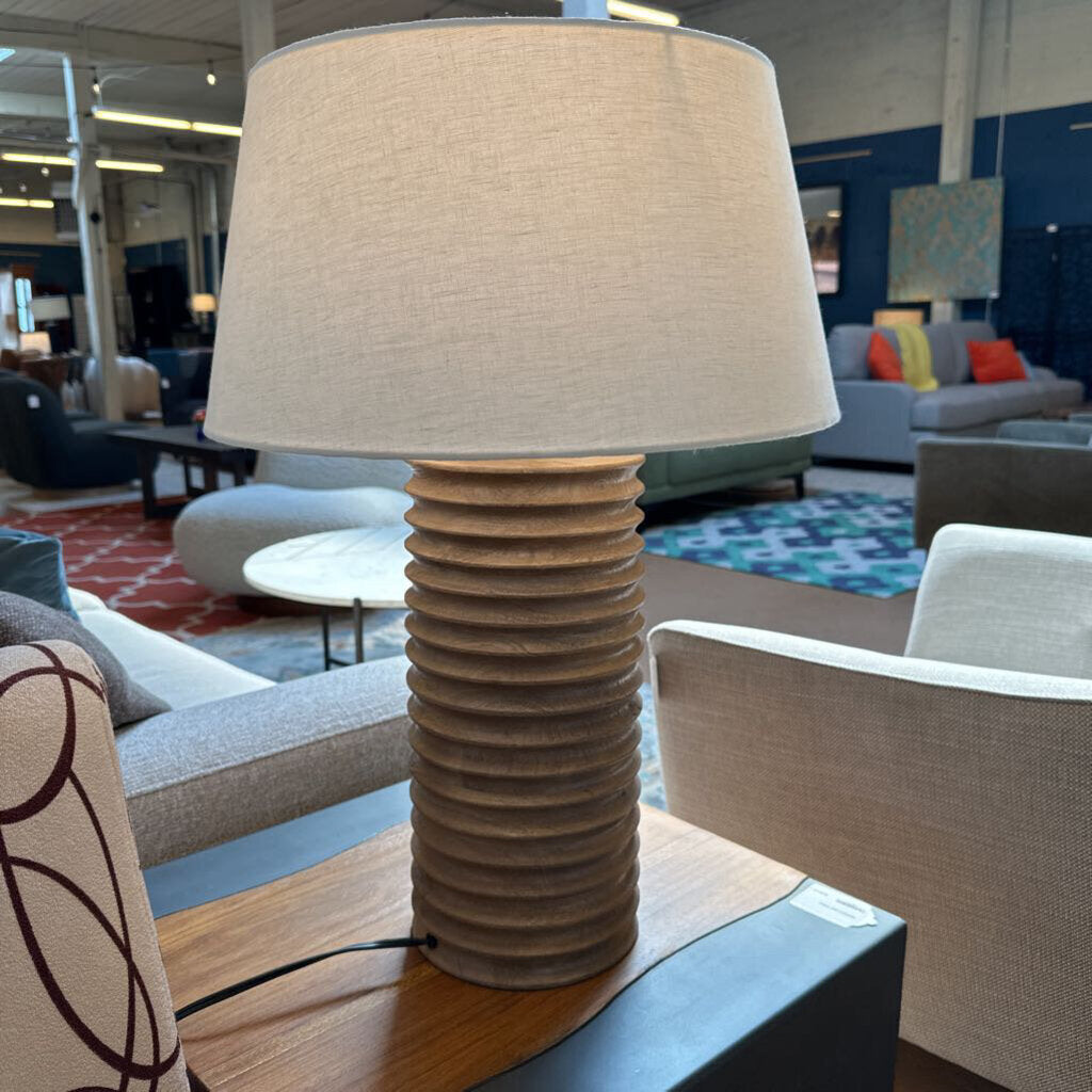 Table lamp with ribbed base on a table in a living room setting