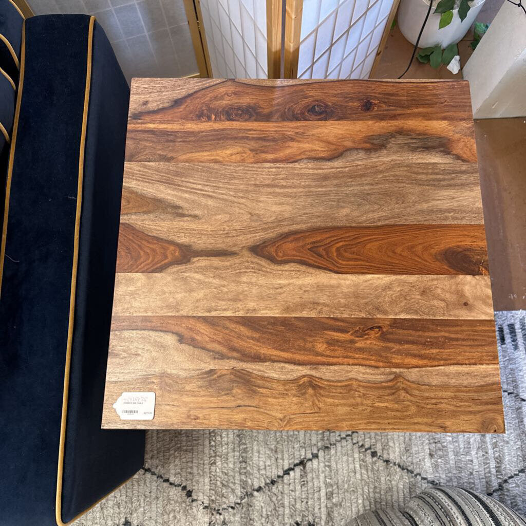 Wooden surface with a visible brand label on a patterned rug