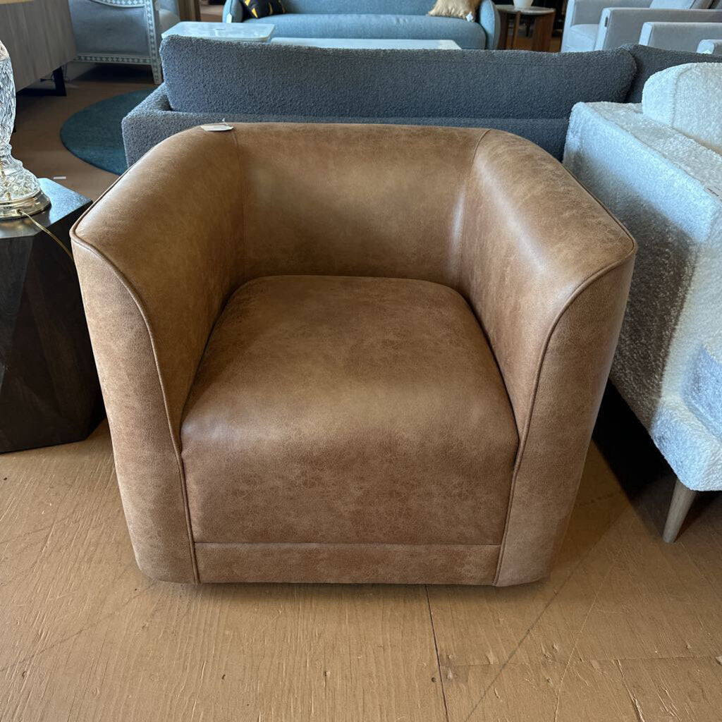 Brown armchair in a showroom setting with other furniture.