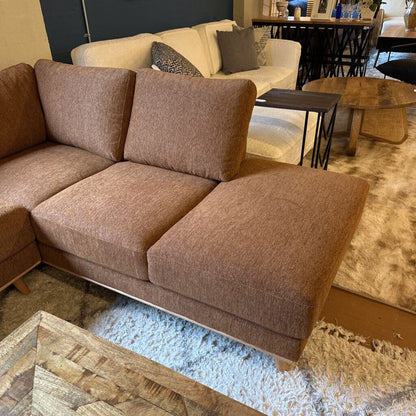Brown sectional sofa in a living room setting with a beige couch and coffee table.