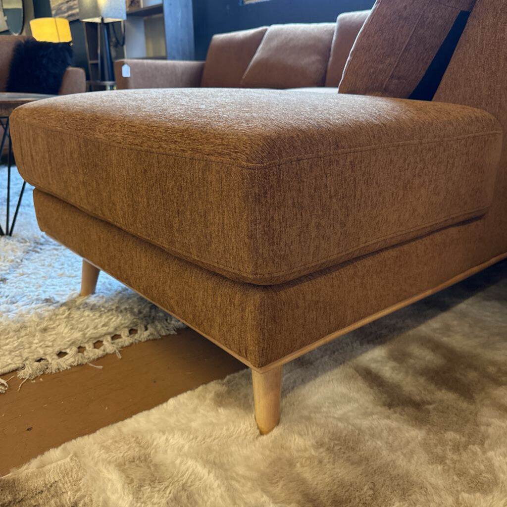 Brown textured ottoman on a carpeted floor