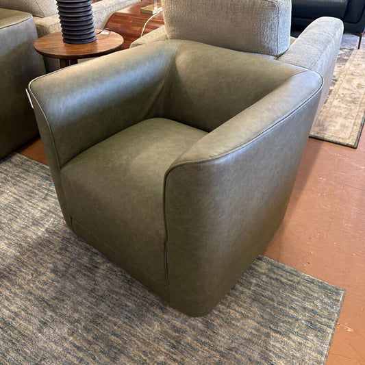 Green armchair on a rug with a blurred background