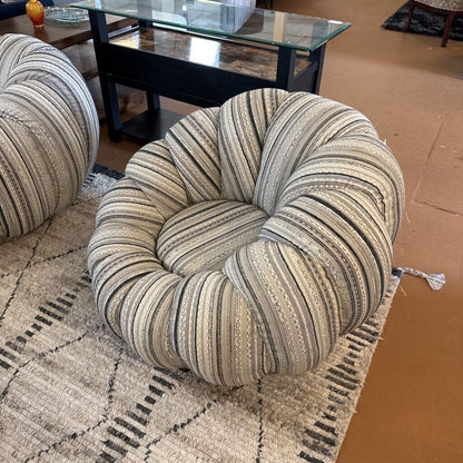 Round striped cushion on a textured rug with a coffee table in the background