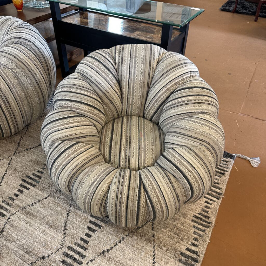 Striped cushion on a textured rug with a glass coffee table in the background