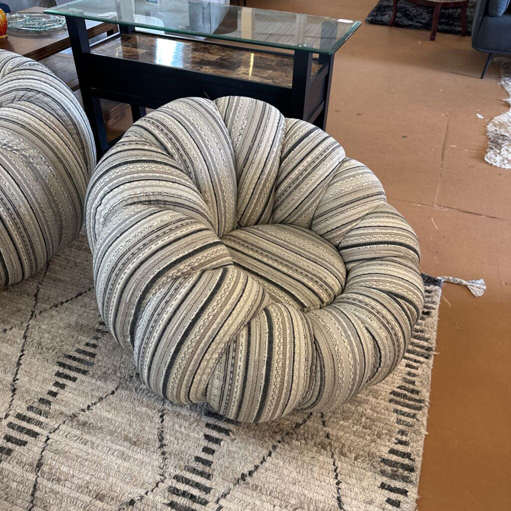 Striped donut-shaped cushion on a patterned rug with a coffee table in the background.