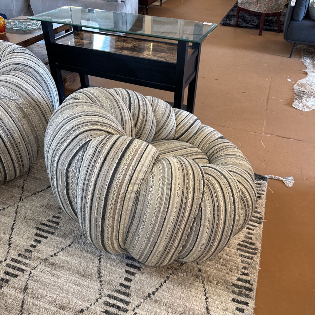 Textured ottoman in a living room setting with a glass coffee table and cardboard box in the background.