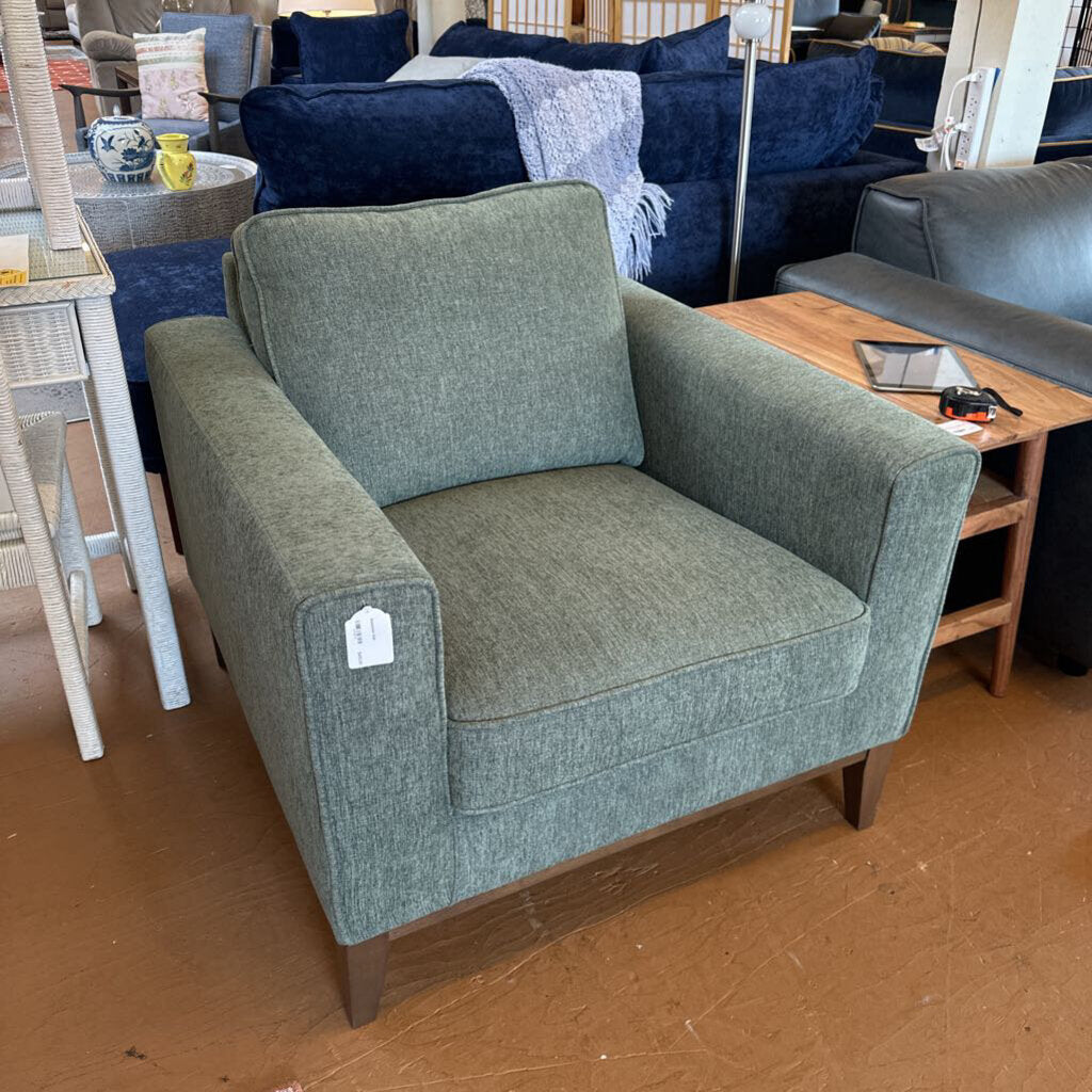 Green armchair in a showroom with other furniture in the background