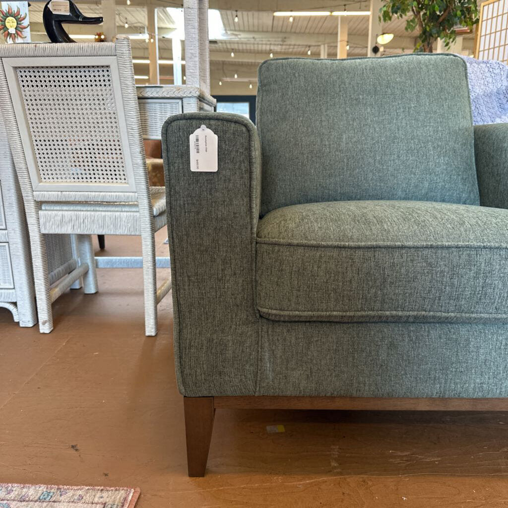 Gray upholstered chair with a price tag in a store setting