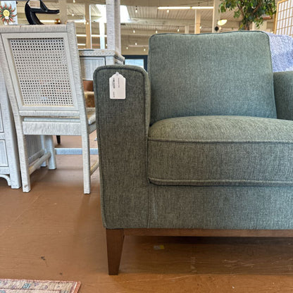 Gray upholstered chair with a price tag in a store setting