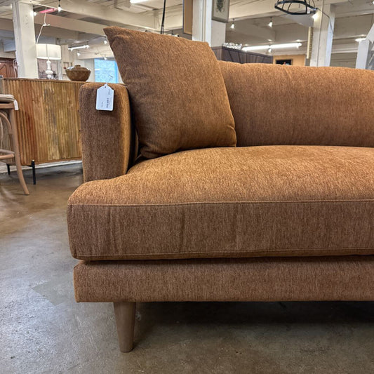 Brown sofa with a price tag in a store setting