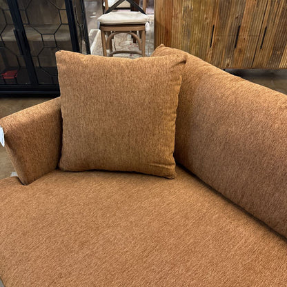 Brown sofa with a pillow in an indoor setting
