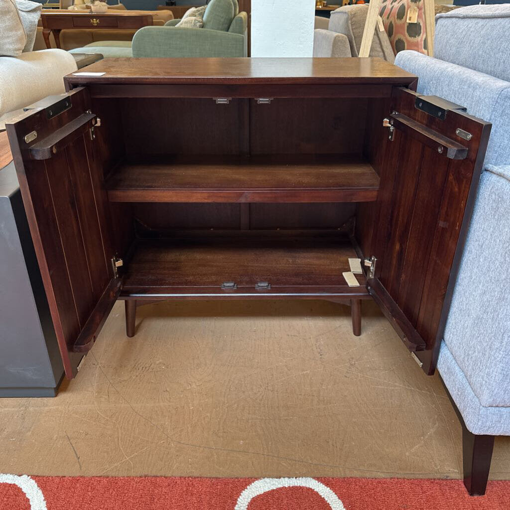 Wooden sideboard with open doors in a furniture store setting
