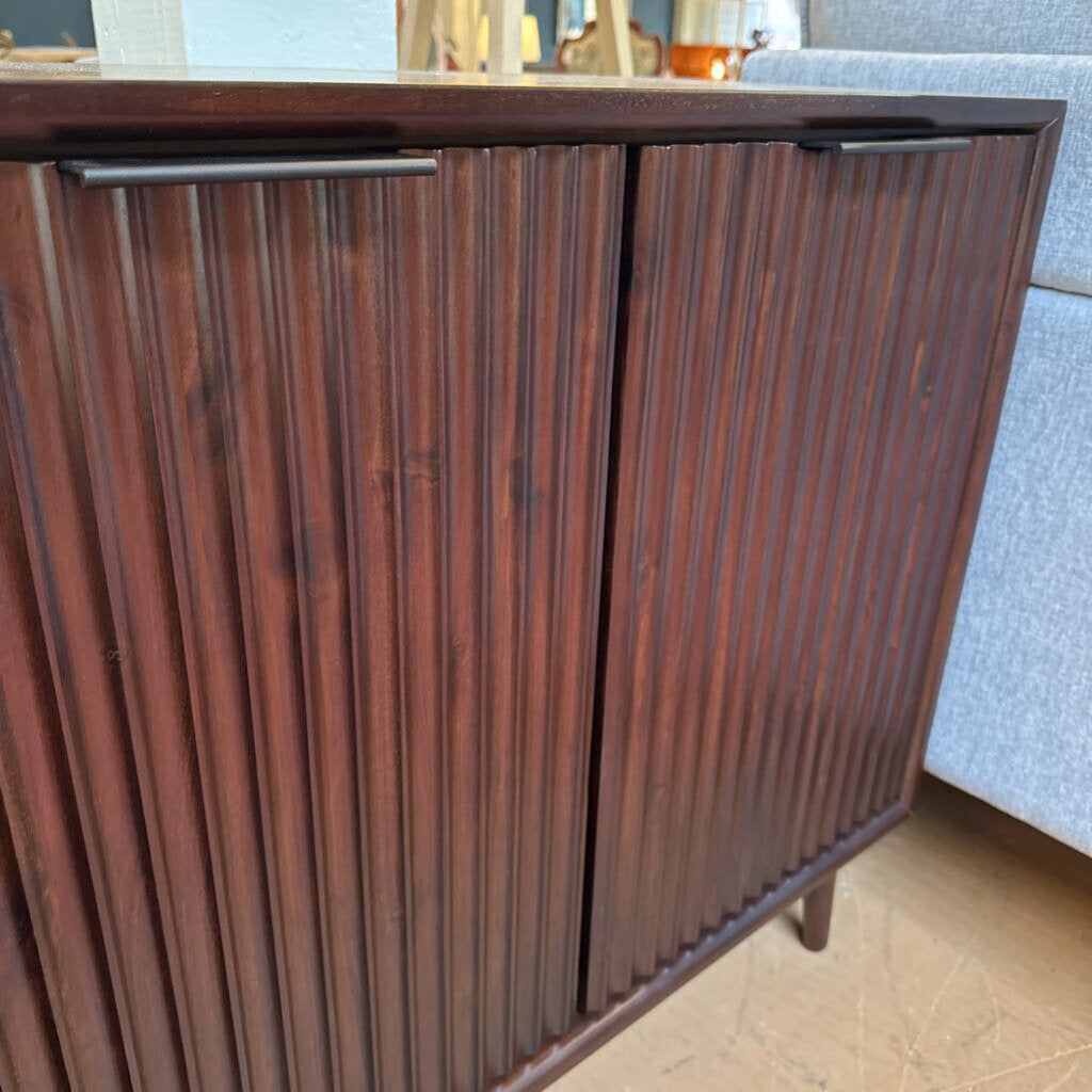 Wooden cabinet with ribbed design in a room setting