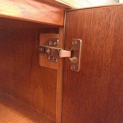 Close-up of a wooden cabinet with a metal hinge