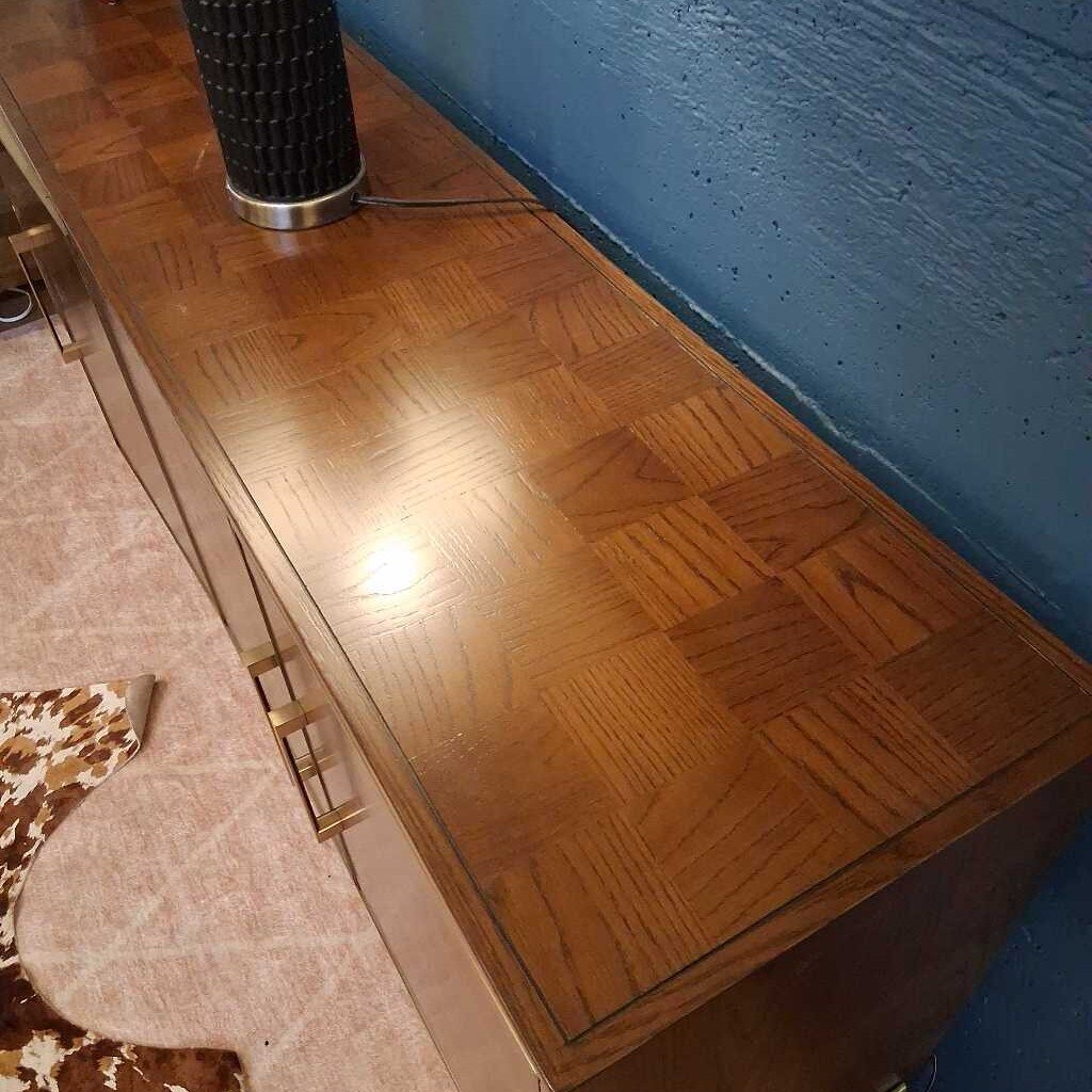 Wooden console table with decorative lamp against a blue wall