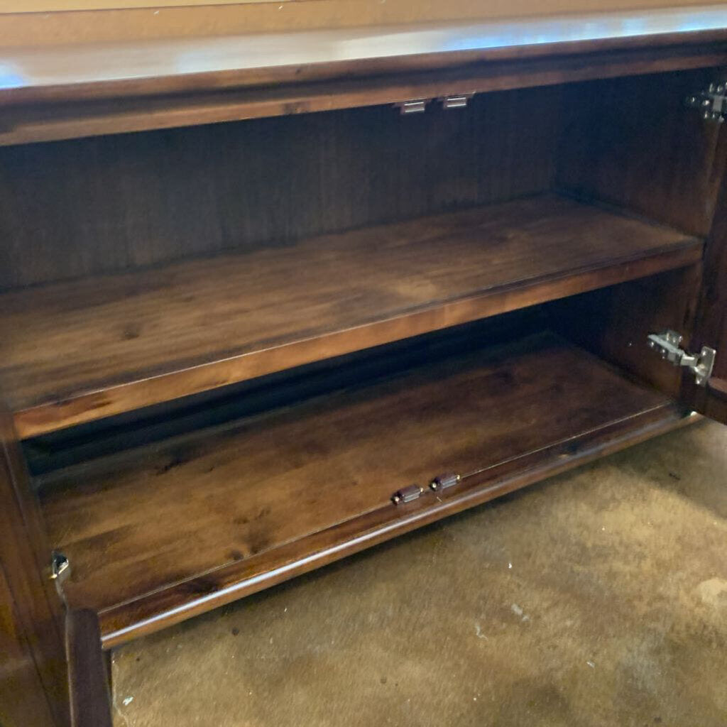 Wooden cabinet with open doors on a concrete floor