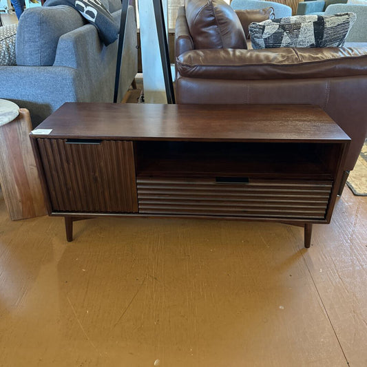 Wooden entertainment console in a room with furniture