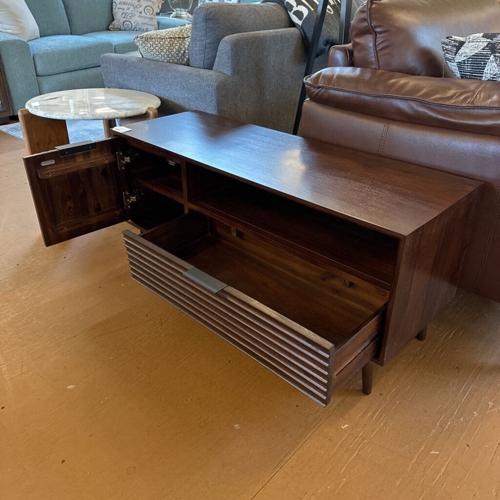 Wooden coffee table with open drawer in a living room setting