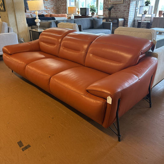 Brown leather sofa in a room with other furniture and decor.