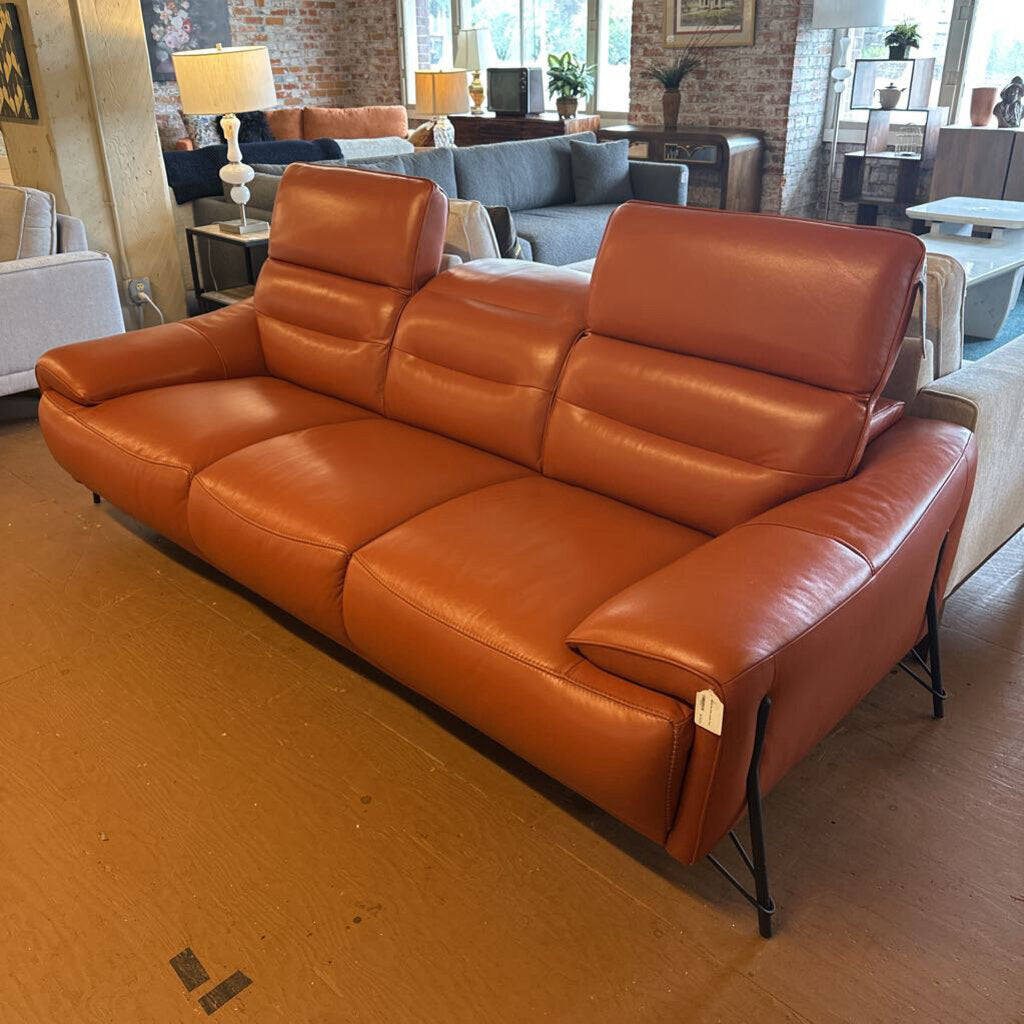 Brown leather sofa in a living room setting with other furniture.